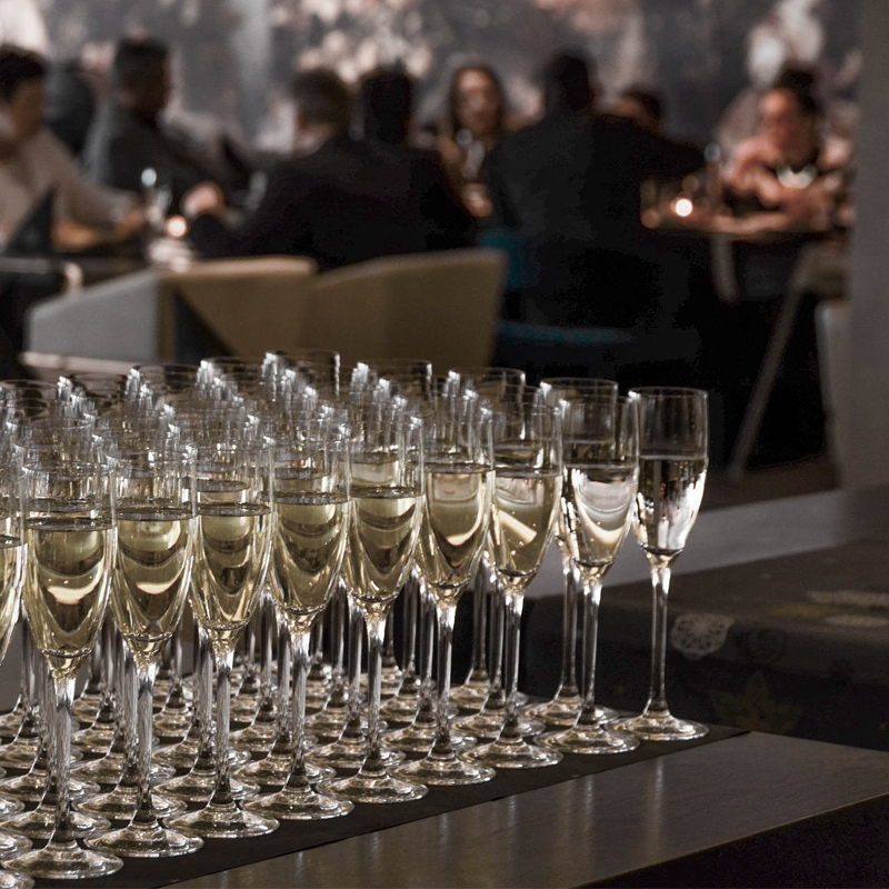 Sala de jantar movimentada com taças de vinho