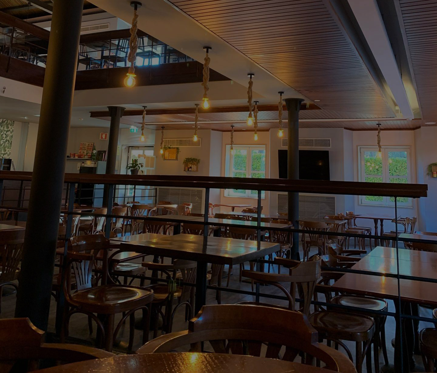 Sala de jantar com mesas de madeira e balcão